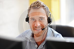 He knows how to sell your product. Portrait of a male customer service representative at his computer.
