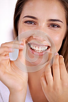 She knows the importance of flossing. Portrait of an attractive young woman holding dental floss and smiling.