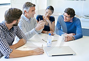 He knows whats best for business. a group of businesspeople discussing work during a boardroom meeting.