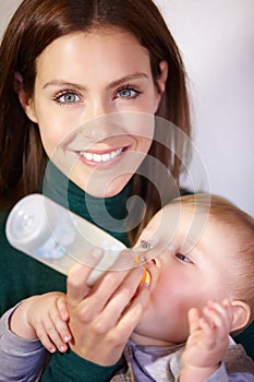 She knows whats best for him - Infant nutrition. Pretty young mother bottle-feeding her infant son.