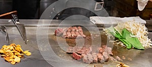 Kobe beef steak or high quality steak on hot plate pan during Teppanyaki Japanese Chef cooking and grilling in restaurant.