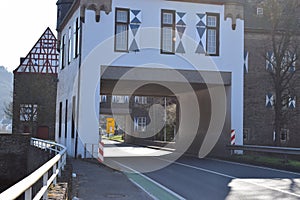 Kobern-Gondorf, Germany - 03 24 2021: Main road through the Oberburg with a big yellow traffic sign visible behind