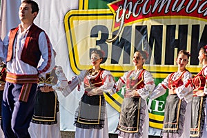 Young men and girls dancing Serbian traditional national folk dance Kolo