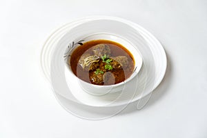Kofta Curry, Delicious Meat Balls in thick spicy gravy in bowl on white background