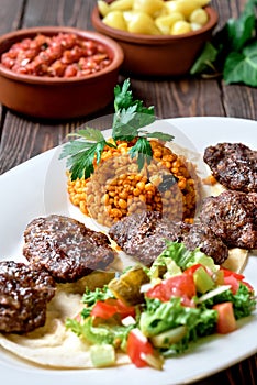 Kofte kefte - Turkish cutlets meat balls made from lamb and beef meat and spices, cooked over charcoal. Served on a platter