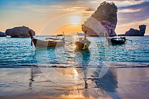 Koh Phi Phi Don with anchored long tail boats at sunset, Thailand. Vacation, travel and holiday concept