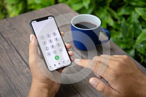 Man hand holding iPhone X with call number on screen