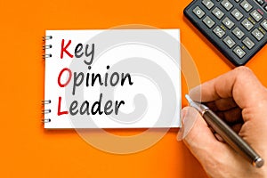 KOL key opinion leader symbol. Concept words KOL key opinion leader on white note on a beautiful orange table orange background.