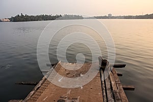 A wooden pier on the edge of the waters of the Ashtamudi lake in the town of Quilon