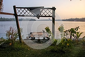 A wooden pier by the green banks of the Ashtamudi lake in the town of Quilon