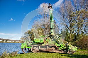 Komatsu amphibious dozer on a river bank in autumn day.