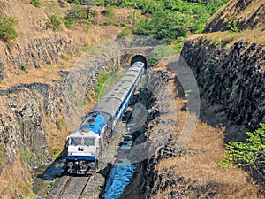 Train coming out of a tunnel in Konkan region of Maharashtra, India. photo