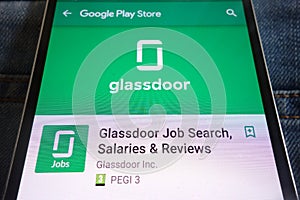 Glassdoor Job Search app on Google Play Store website displayed on smartphone hidden in jeans pocket