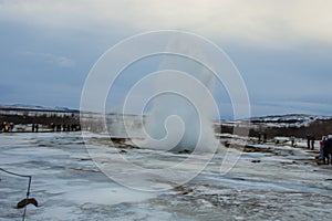 Konungshver geyser steams- Strokkur geyser erupts in the background, in Iceland