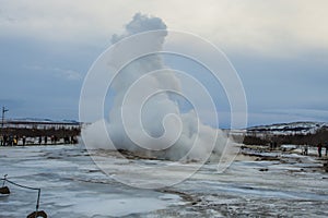 Konungshver geyser steams- Strokkur geyser erupts in the background, in Iceland