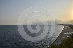 Konyaalti beach and Mediterranean sea at mountains background during sunset in Antalya, Turkey