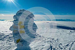 Kor Alps - Frozen directional path marks with panoramic view of Karwanks and Julian Alps seen from Grosser Speikkogel