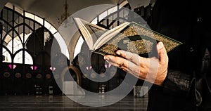 Koran with muslims man . Mosque background . Koran - holy book of Muslims