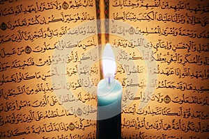 Koran or quran holy book with candle on candlelight