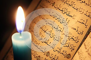 Koran or quran holy book with candle on candlelight