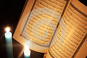 Koran or quran holy book with candles