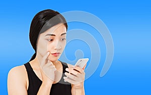 Korean,asian woman reads news carefully isolated on dark blue background,girl hol phone,copy space photo