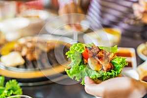 Korean BBQ bulgogi beef and lettuce held in hand, Selective focus