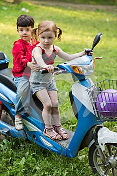 Korean boy and caucasian girl on a blue scooter on