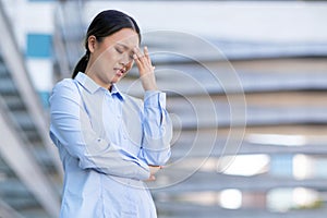 Korean businesswoman crying upset suffering from stress and headache outdoor