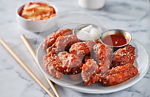 Korean chicken wings in gochujang sauce with kimchi and pickled radish