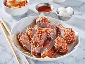 Korean chicken wings in gochujang sauce with kimchi and pickled radish