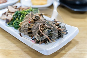 In Korean cuisine, side dishes such as seasoned vegetables are served on a white plate