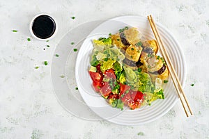 Korean egg rolls. Eggs omelet rolls with rice, nori and fresh salad on a white plate.