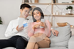 Korean Family Couple Shopping Using Smartphone Mobile Application At Home