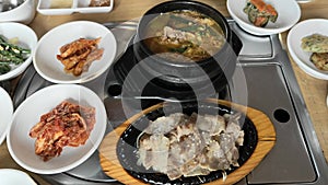 Korean food with grilled meat, soup and side dishes.