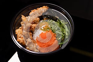 Korean fried chicken dressed with spawn and  Seaweed served in a black bow plastic