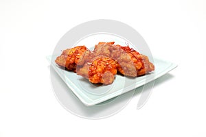 Korean fried chicken on a plate isolated on a wooden background