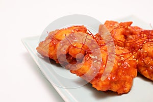 Korean fried chicken on a plate isolated on a wooden background