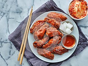 Korean fried chicken in spicy gochujang sauce with kimchi and pickled radish top down