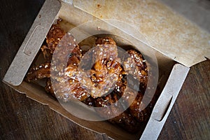 Korean Fried Chicken wings and drummets in a take away box. Traditional asian recipe