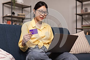 Korean Lady Shopping Using Credit Card And Laptop Sitting Indoors