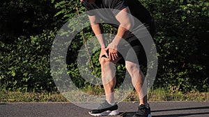 Korean male jogger having painful knee injury during jogging.