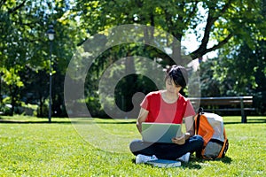 Korean male student learning at computer at campus of university