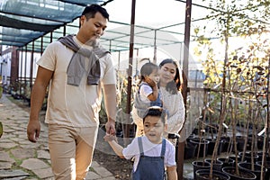 Korean man and his charming wife with cute children are buying green planters home