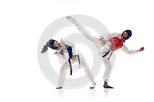 Korean martial art. Asian sport wrestling, fighting battle. Two young girl in white dobok, kimono practicing taekwondo