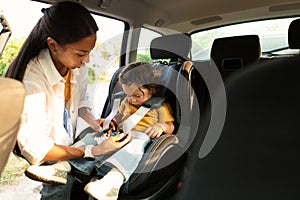 Korean Mom Sitting Down Baby In Safe Seat In Automobile