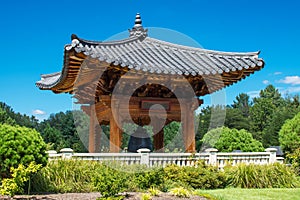 Korean pagoda and harmony bell in a park under blue sky in Virginia