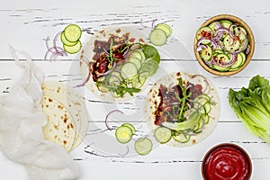 Korean slow cooked beef tacos with asian cucumber slaw and sriracha ketchup. Top view, flat lay