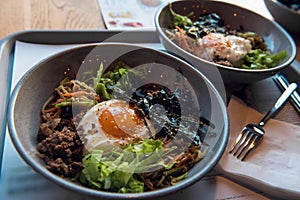 Korean spicy salad of seaweed and spinach with fried egg