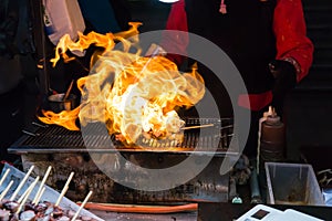 Korean street food, squid skewer is cooking with flame photo